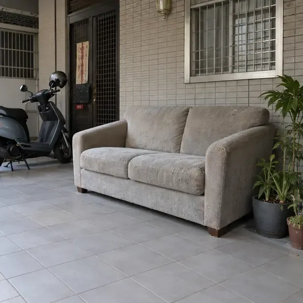 一張沙發暫放在住家有遮蔽的入口內側，未占用外側道路