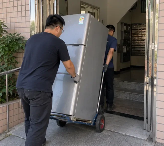 兩名搬運人員用手推車將冰箱平穩移出住宅入口，示意一般人力搬運情境