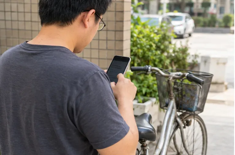民眾站在老舊腳踏車旁以手機查詢或聯絡清運資訊，畫面位於住宅入口