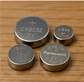 木製の机に並べたサイズの異なる丸形電池