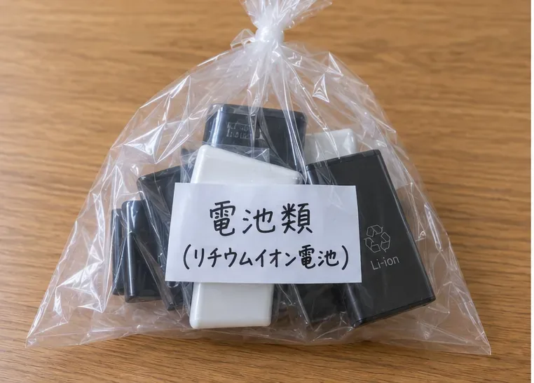 複数の小型充電池とモバイルバッテリーを透明なビニール袋にまとめた様子