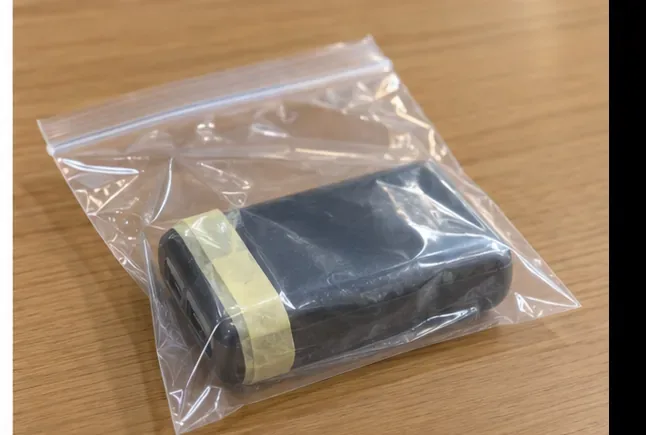 端子をテープで絶縁したモバイルバッテリーを透明袋に入れた状態