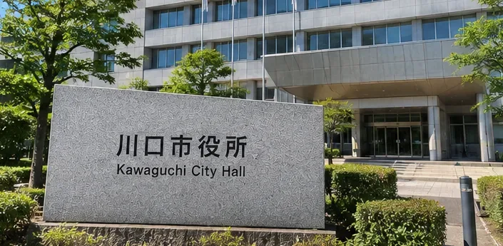 川口市役所と書かれた石の案内板と庁舎入口の外観