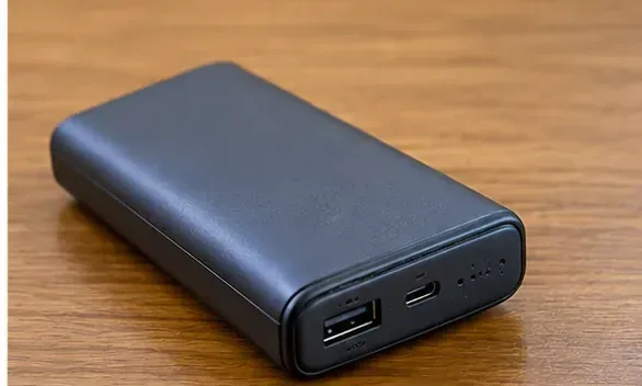 木製の机の上に置かれた黒いUSB端子付きモバイルバッテリー