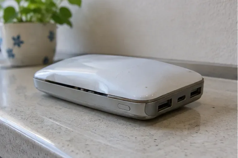 外装の中央部が膨らみ、ケースの合わせ目が開いた白いモバイルバッテリー