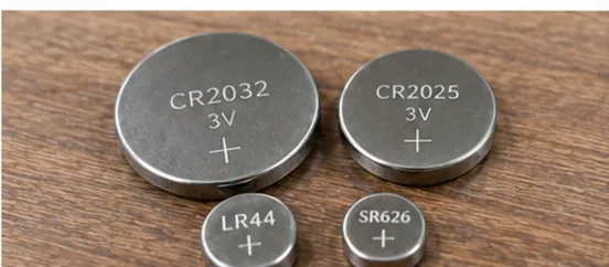 木製の机にCR2032、CR2025、LR44、SR626と表示された丸い電池が並んでいる様子