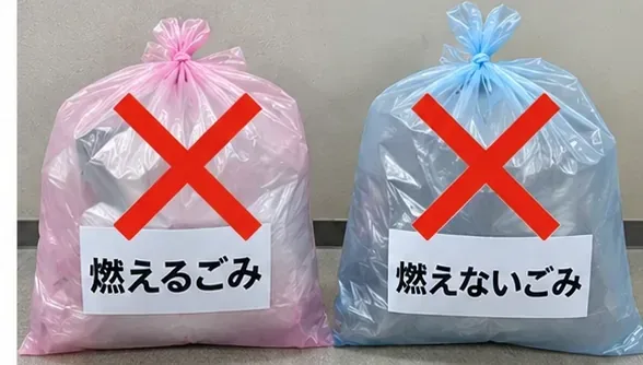 燃えるごみと燃えないごみの袋に大きな赤いバツ印が付けられている様子