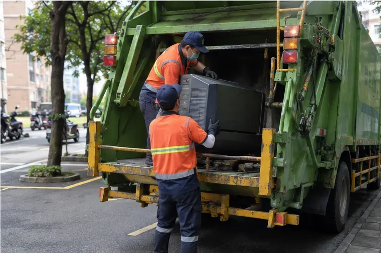 清潔人員將完整舊電視搬上資源回收清運車，電視未被拆解