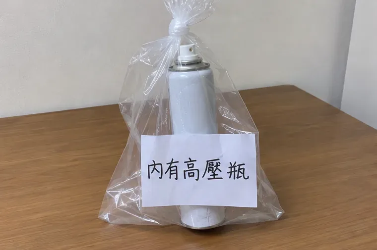 白色噴霧罐單獨裝入透明袋中，袋外貼有內有高壓瓶的清楚標示