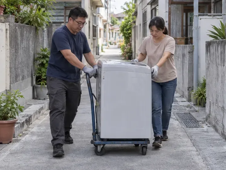 兩名住戶以家電搬運推車移動洗衣機，並留出住宅巷道通行空間。
