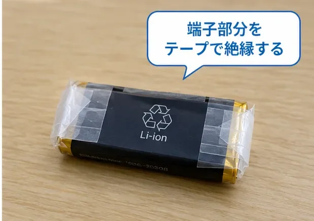 リチウムイオン電池の端子部分を複数箇所テープで覆い、絶縁状態を確認している様子