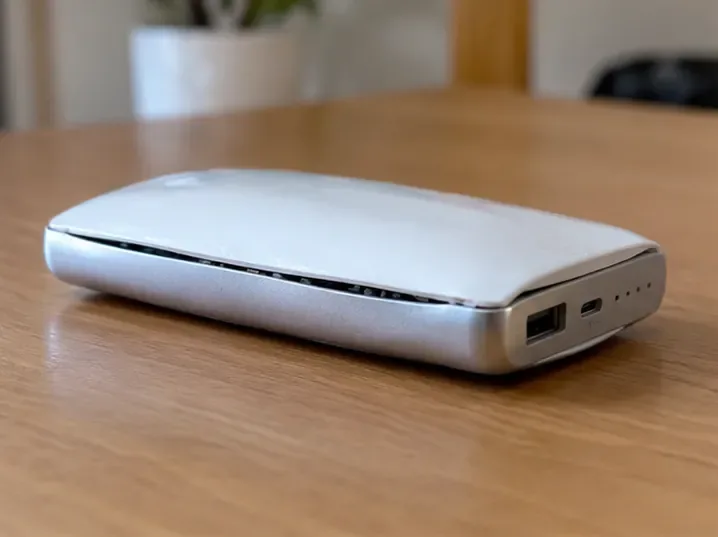 ケース中央が膨らみ、合わせ目が開いた白いモバイルバッテリー