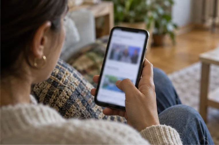 Una persona consulta gli aggiornamenti elettorali su uno smartphone mentre è seduta a casa