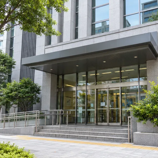 臺北市一棟現代公共服務建築的入口，玻璃門前有無障礙坡道與植栽
